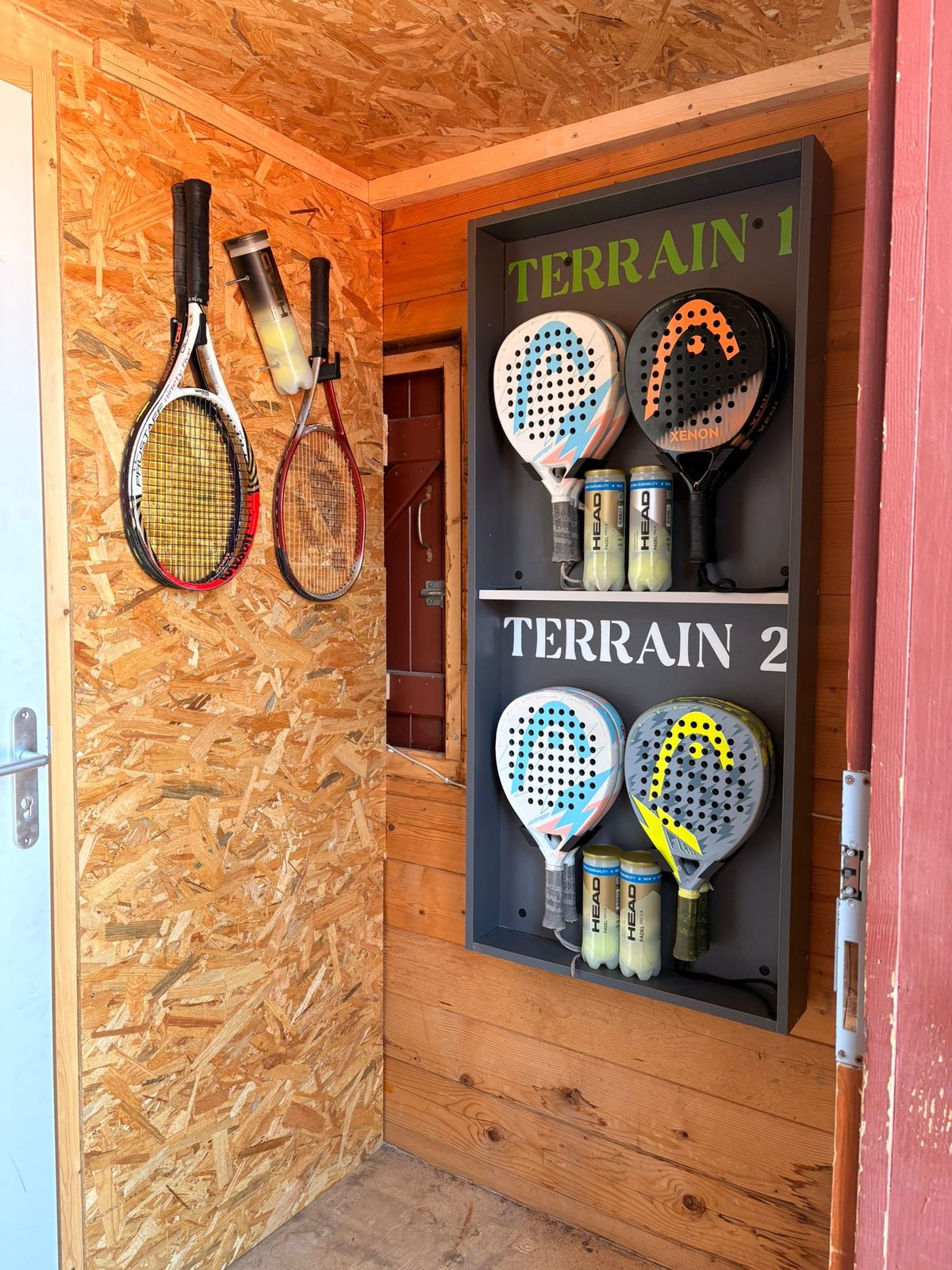 Raquettes et balles rangées par terrain dans le local du chalet